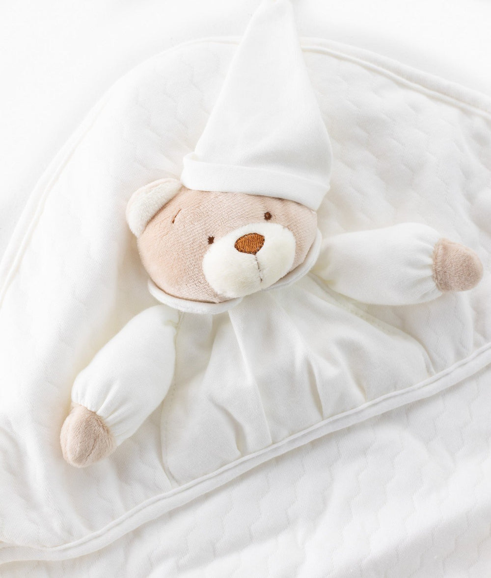 Close-up of textured quilted fabric on 3D beige bear baby swaddle