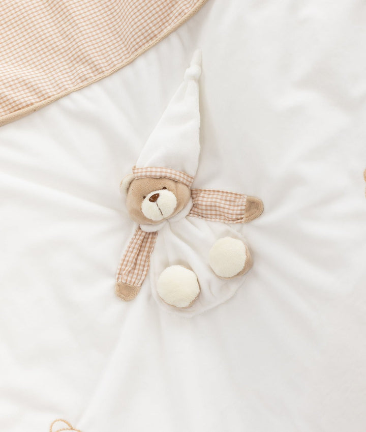 Macro view of 3D plush teddy bear appliqué on white blanket with gingham check ears
