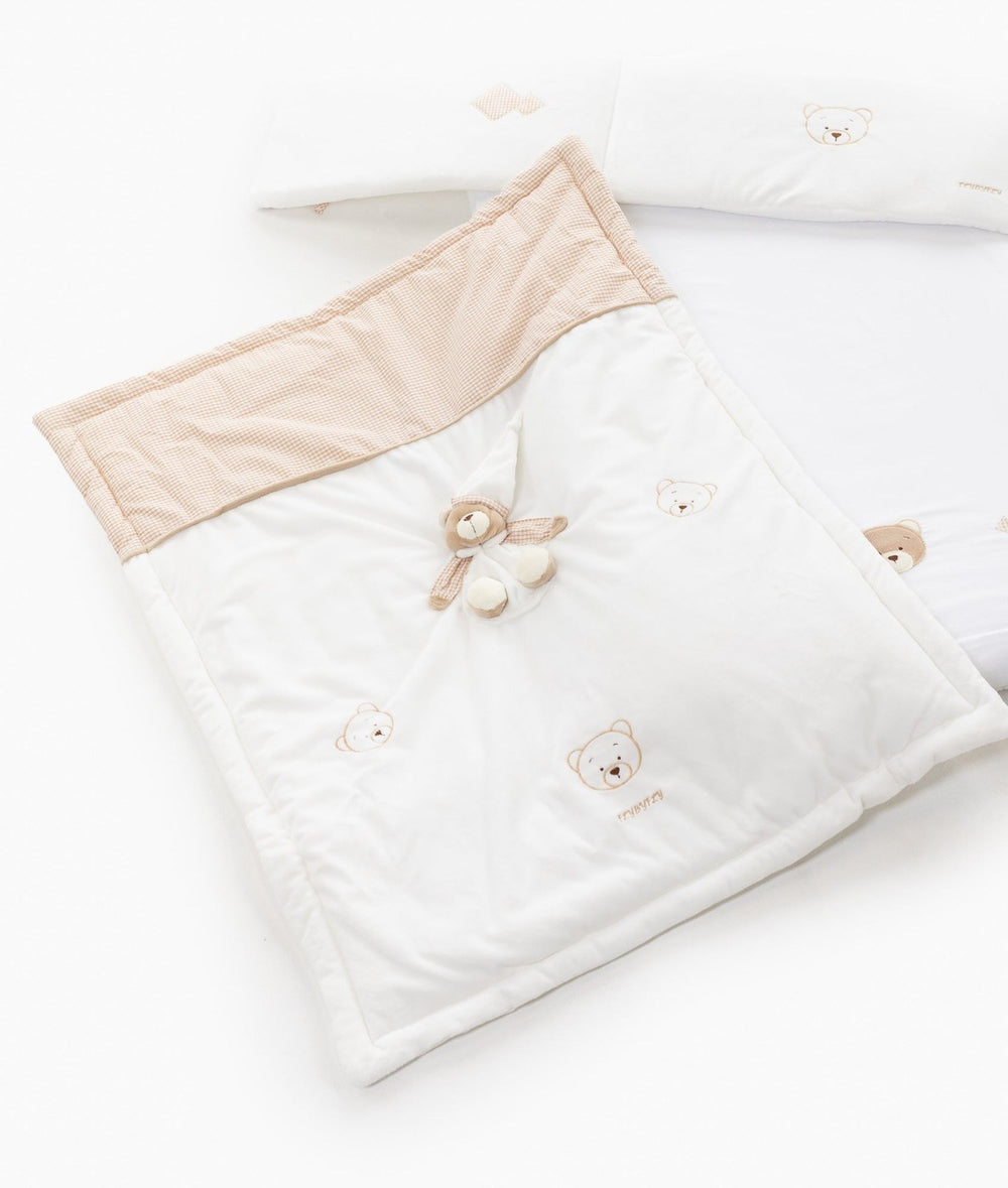 Quilted bassinet blanket with beige waffle-texture border and scattered bear face embroidery