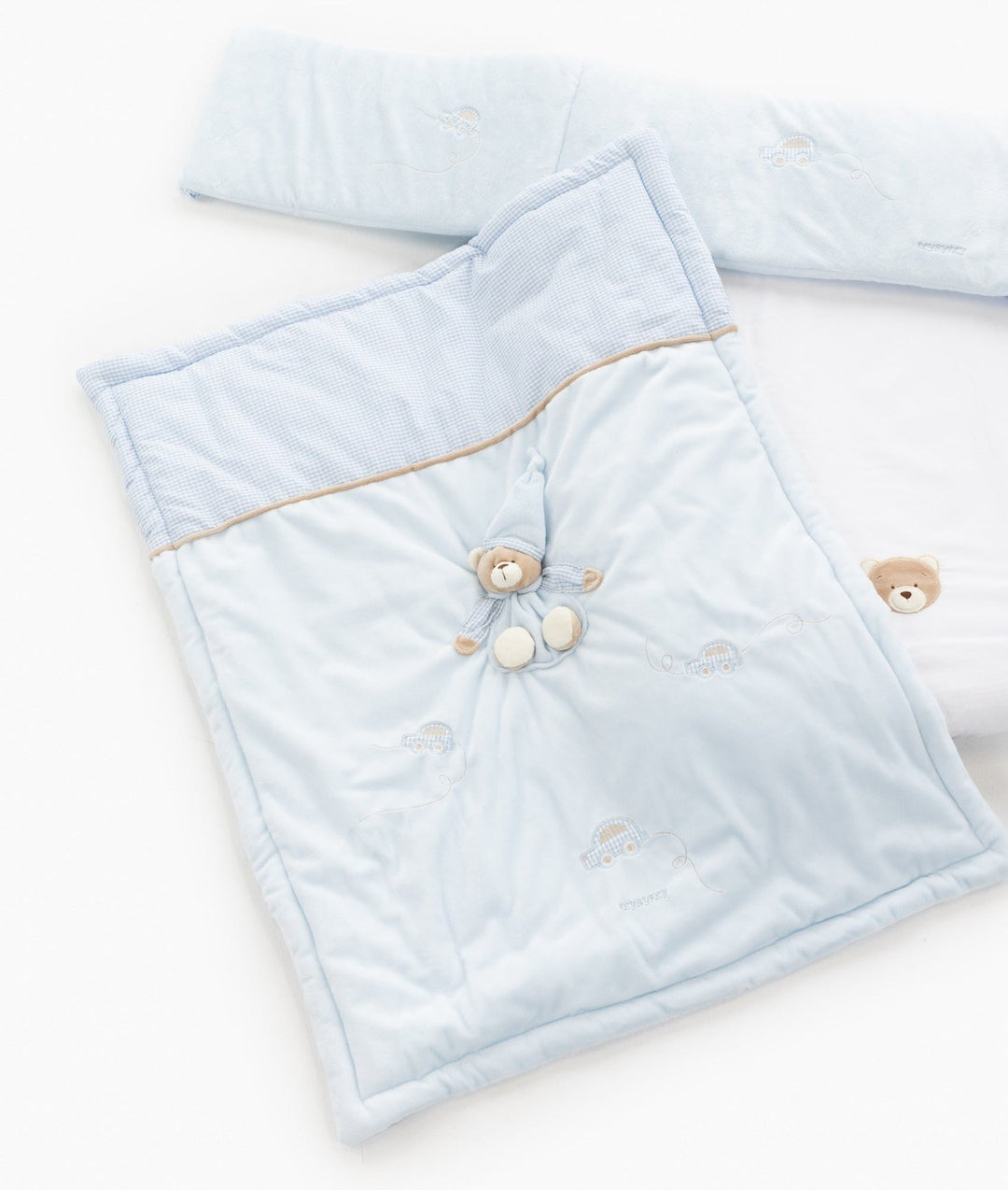 Light blue quilted blanket flat lay with 3D bear, bumper, and white sheet