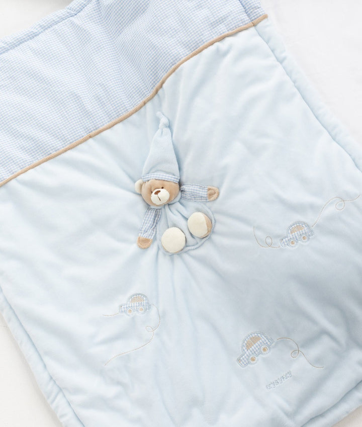 Light blue quilted blanket detail showing gingham trim and sleeping bear applique
