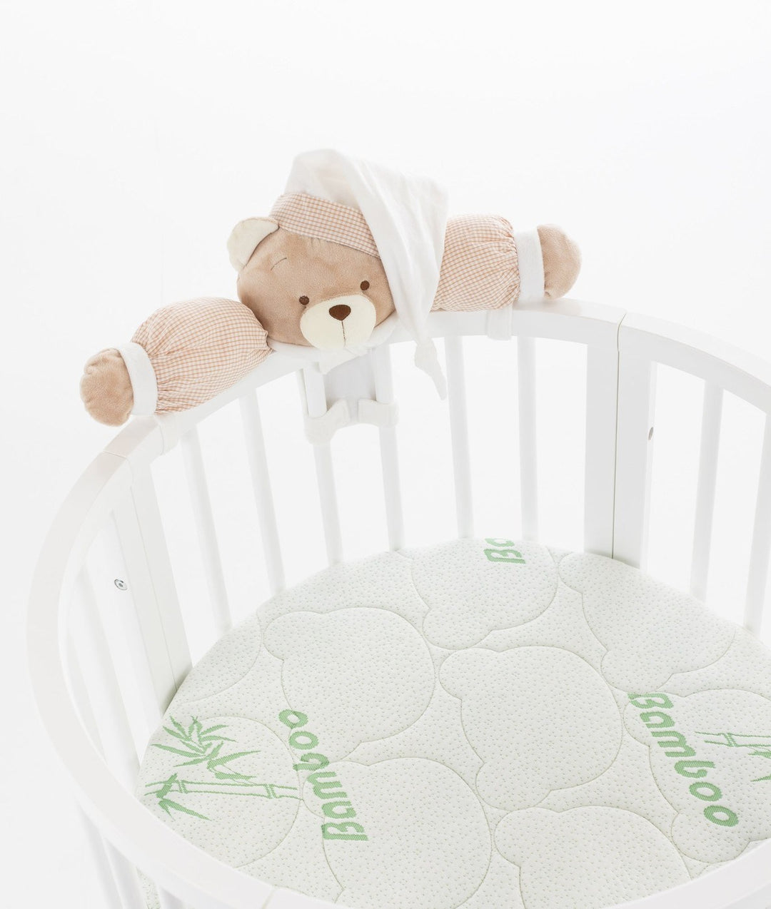 White baby cot with teddy bear design styled in a neutral nursery room