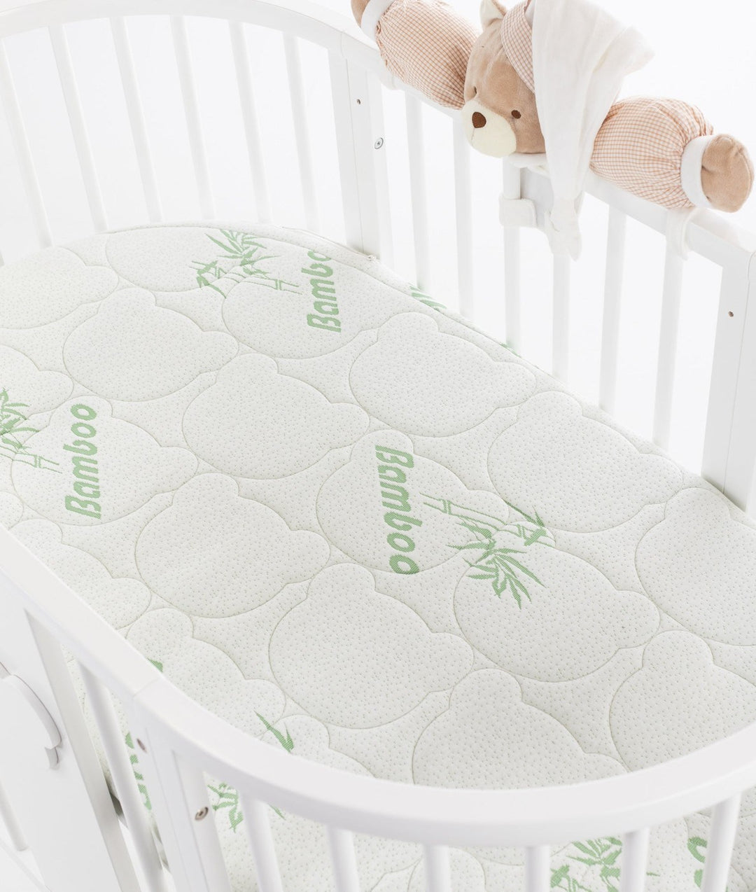 White baby cot with teddy bear design styled in a neutral nursery room