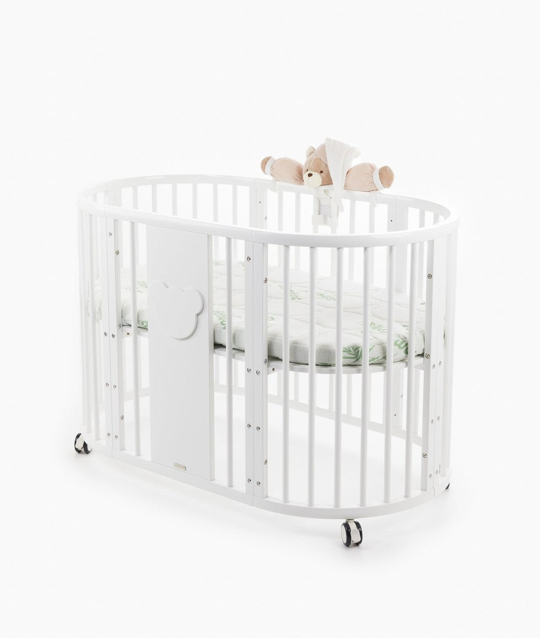 White baby cot with teddy bear design styled in a neutral nursery room