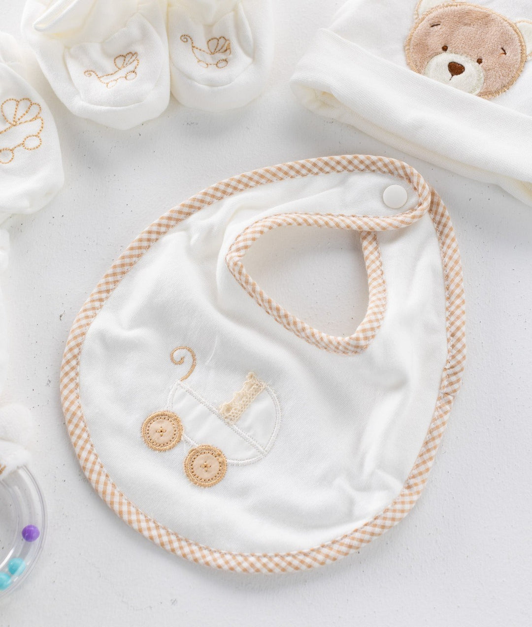 White cotton baby bib with beige gingham trim and embroidered pram design