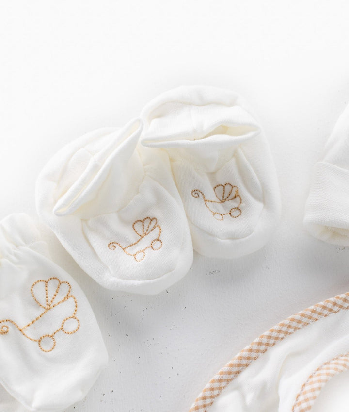 White fabric baby booties with gold vintage carriage embroidery
