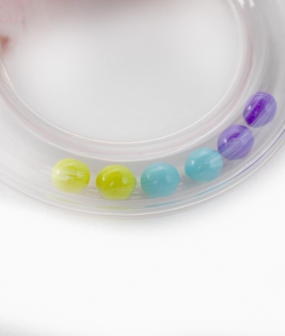 Close-up of clear plastic rattle ring with colorful beads