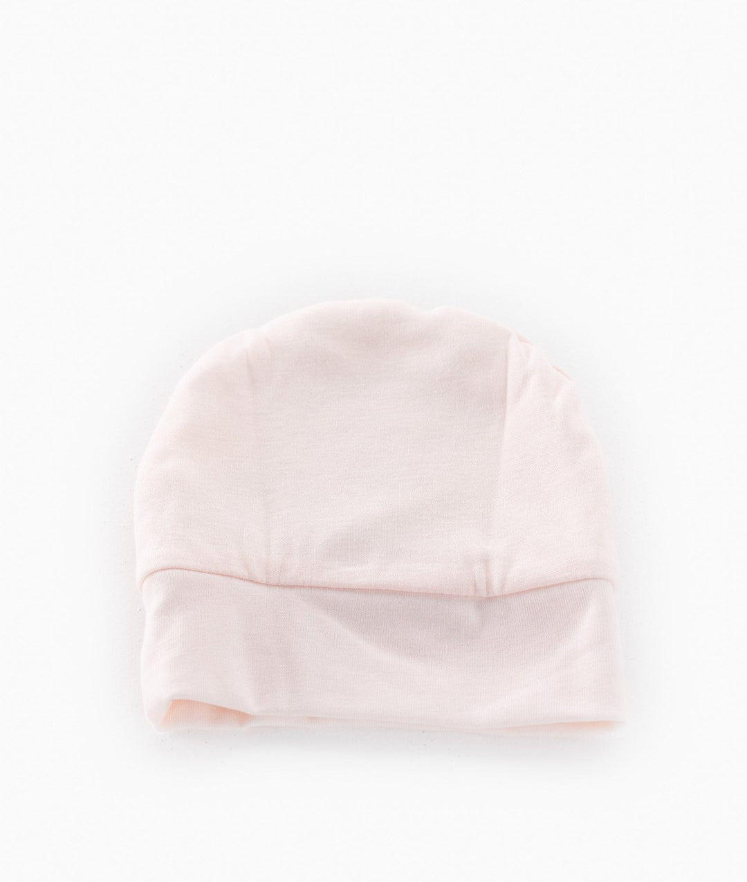 Back view of pale pink baby cotton beanie with seamless crown and ribbed cuff