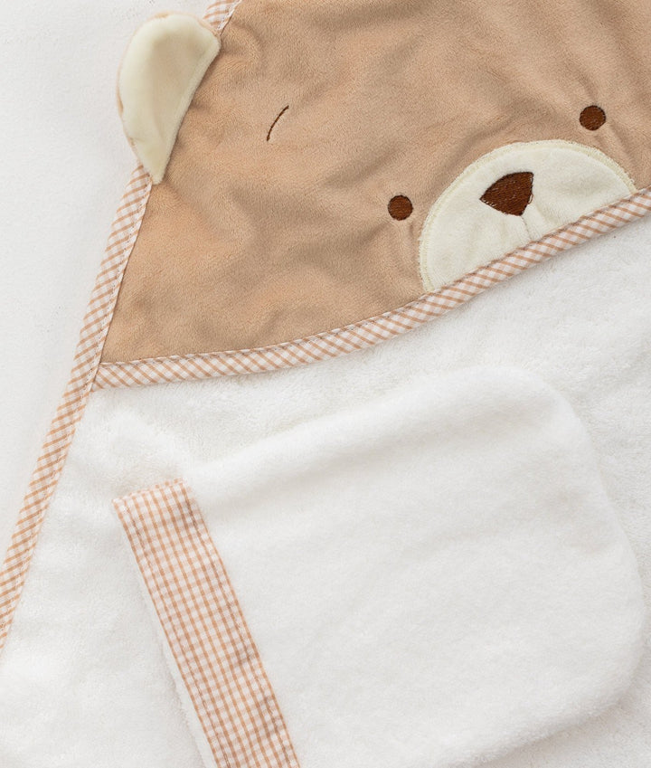 Macro shot of soft cotton texture and beige bear embroidery detail