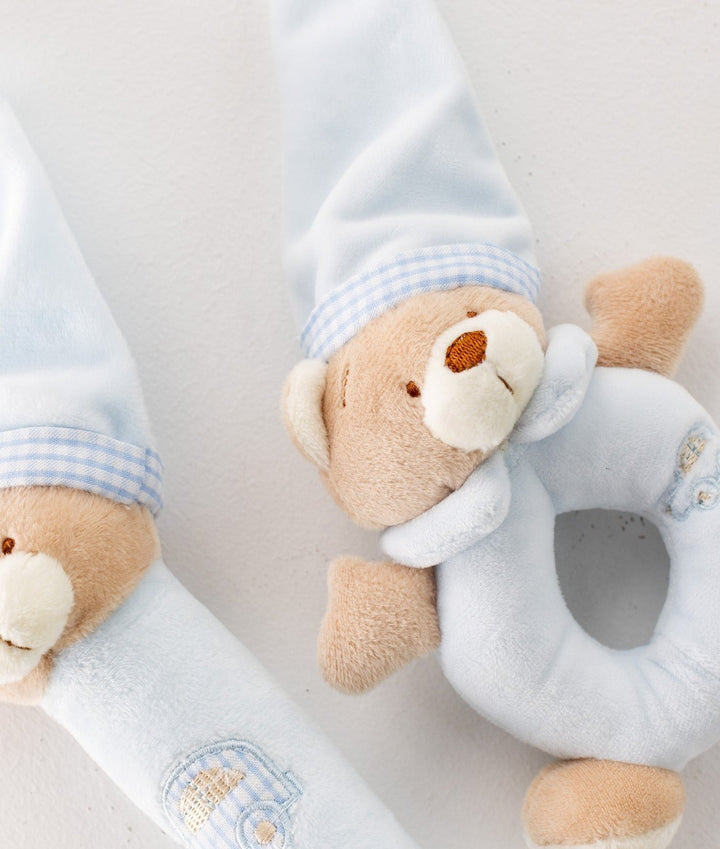 Close-up of textured blue bear activity toy with embroidered car detail
