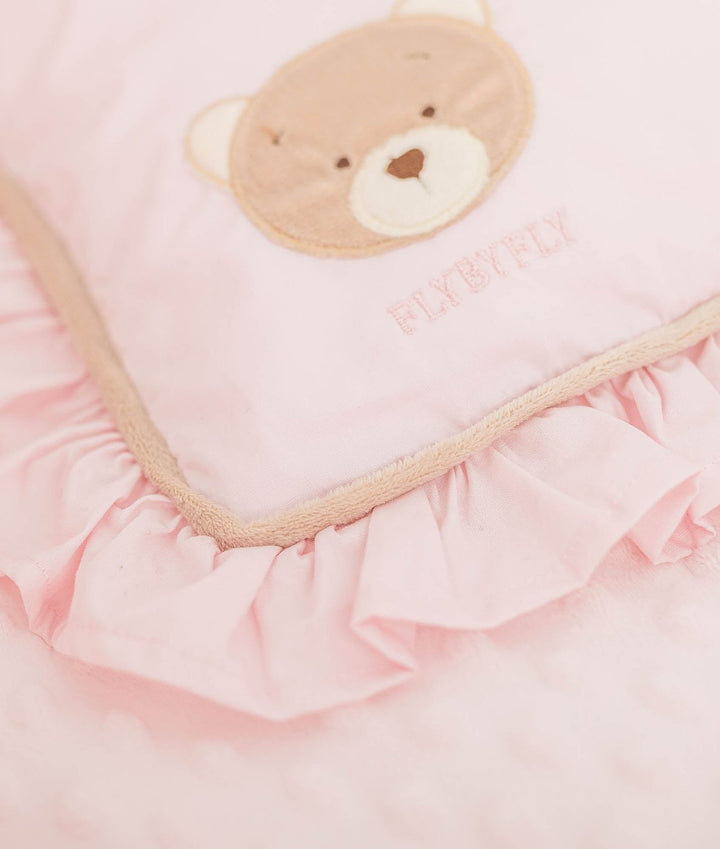 Close up of pink velvet bear face pillow with FLYBYFLY embroidery and piping trim