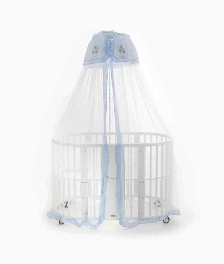 Front view of white oval cot with sheer blue and white canopy draped open to reveal interior and central support stand