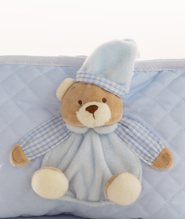 Macro detail of brown embroidered nose, cream feet, and checkered sleeve on plush bear attachment