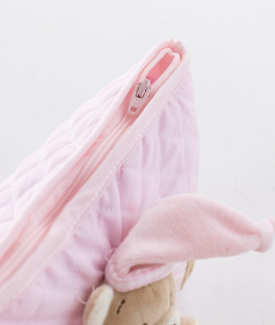 Light pink quilted cotton fabric detail with zipper track on baby pouch