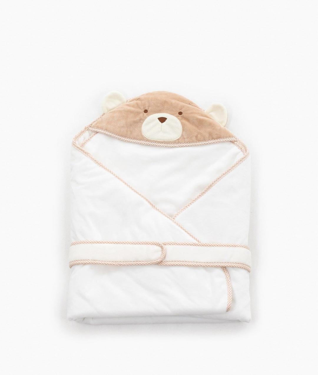 Folded white swaddle with beige trim tie strap for snug baby wrap