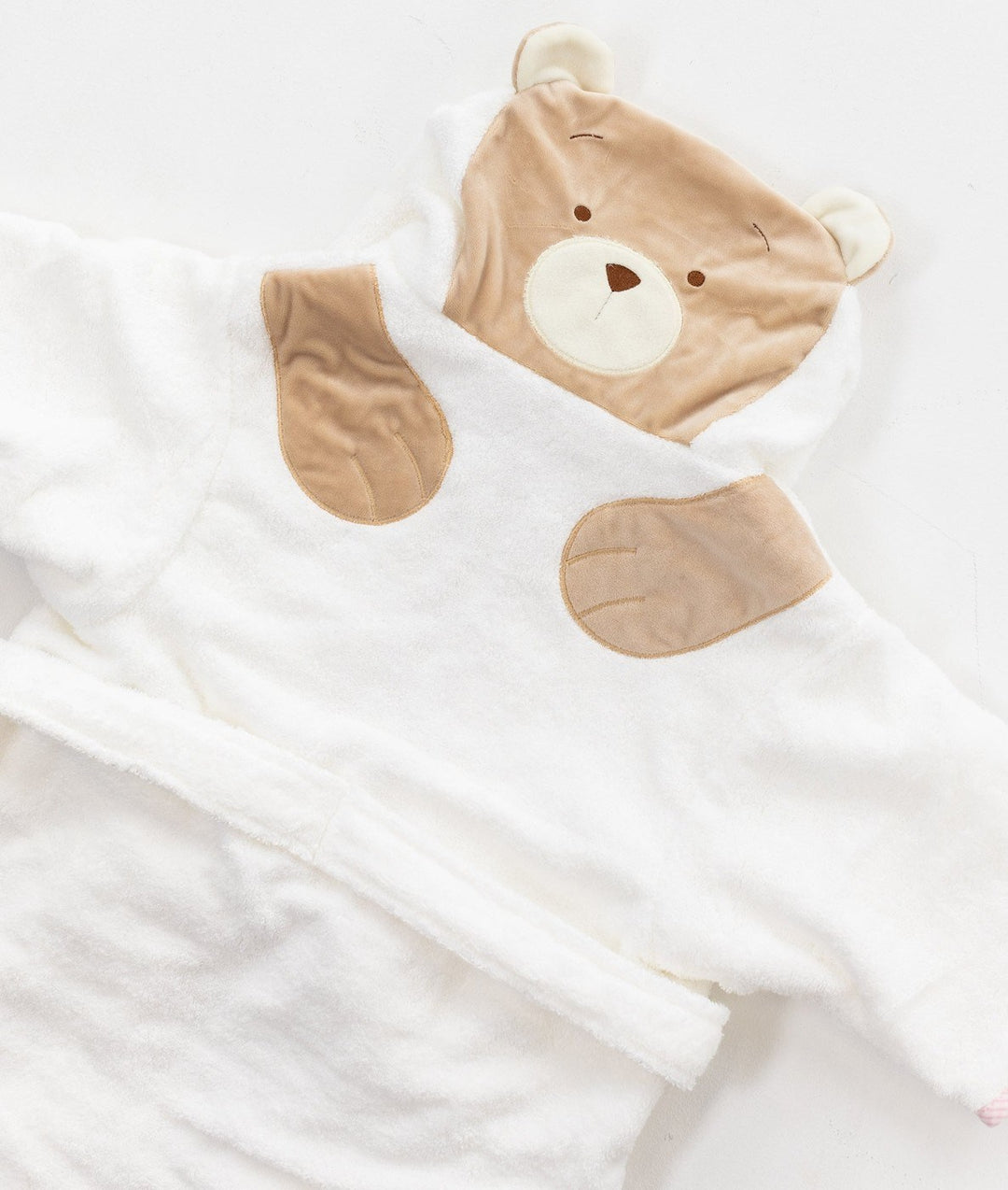 Angled view of white hooded robe showing tan bear paw chest details