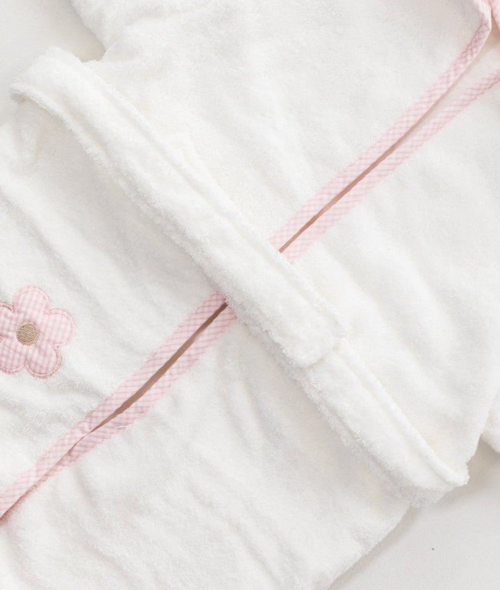 Close up of white terry cloth bathrobe with pink gingham trim detail