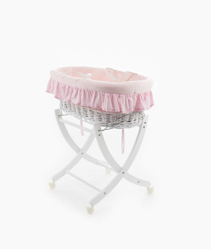 Pink lined wicker bassinet on white X-frame stand with caster wheels