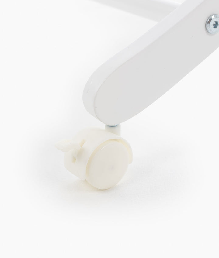Close up of white painted wooden stand leg with locking caster wheel