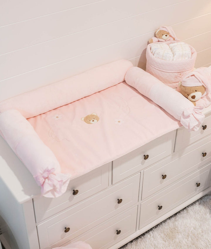 Pink oval changing pad set with embroidered bear face and ruffled bolster pillows