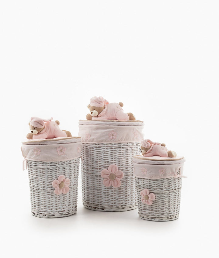 Set of three white wicker storage baskets with pink flower accents