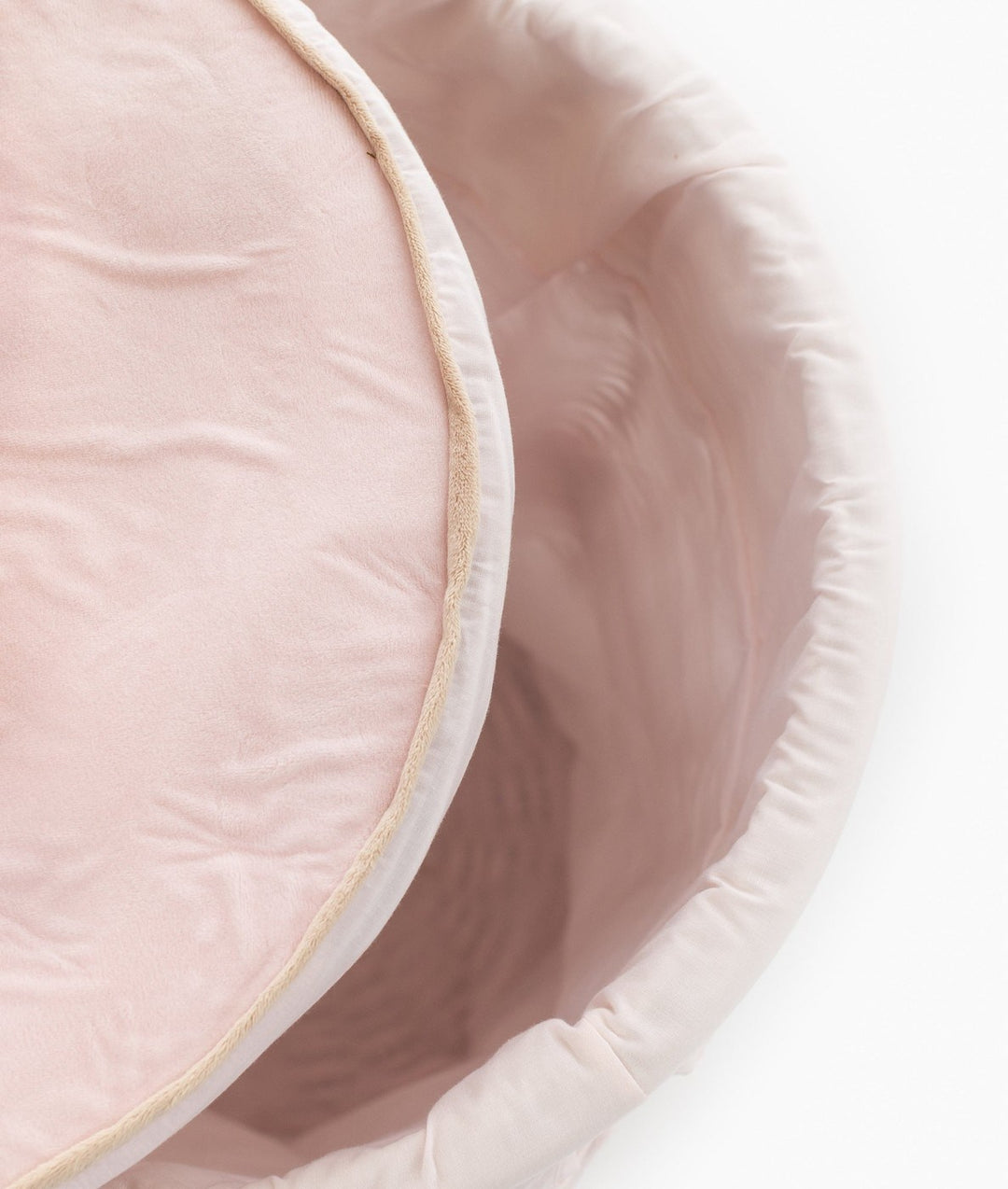 Interior view of white wicker basket showing soft pink removable liner