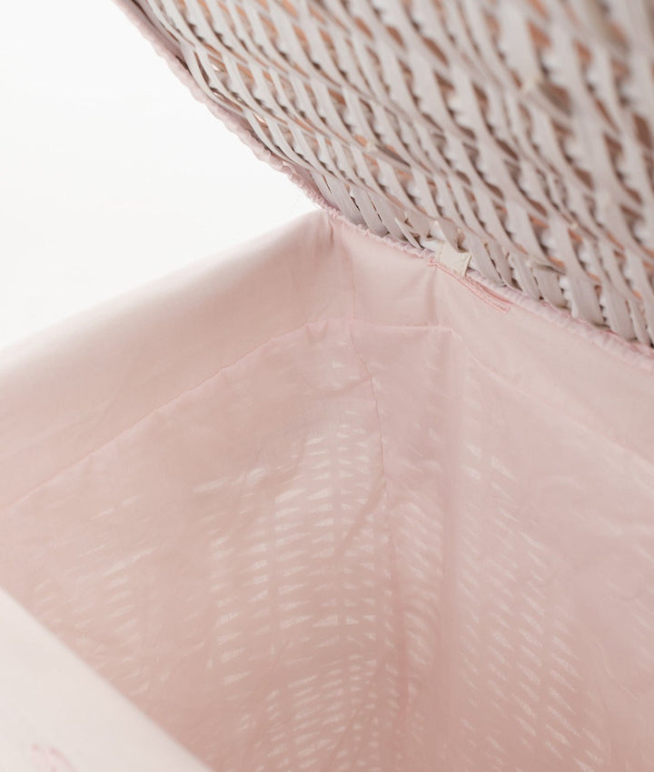 Close-up of smooth light pink fabric lining with elastic binding in wicker basket