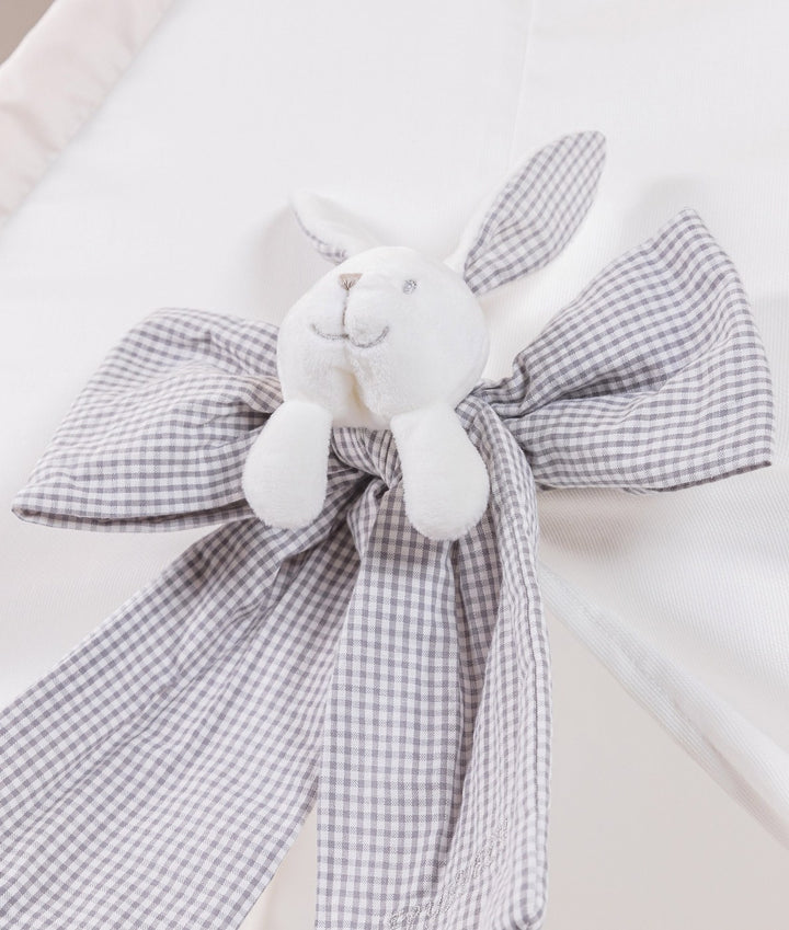 Close-up of grey gingham bunny head bow detail at the top of a white canvas teepee