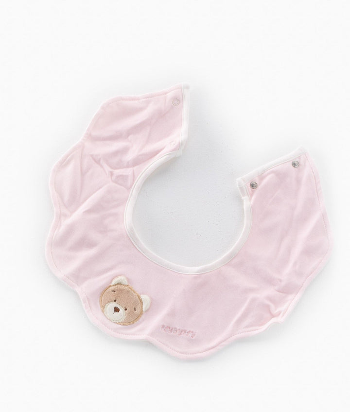 Flat lay of light pink drool bib with teddy bear design and scalloped edges